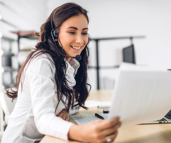 Happy female support representative holding a document at her workplace