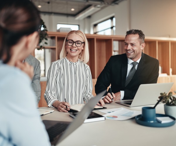 Laughing group of businesspeople working around an office table