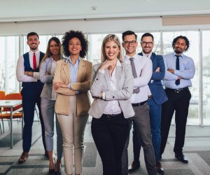 Group of happy business people standing in a line and facing the camera