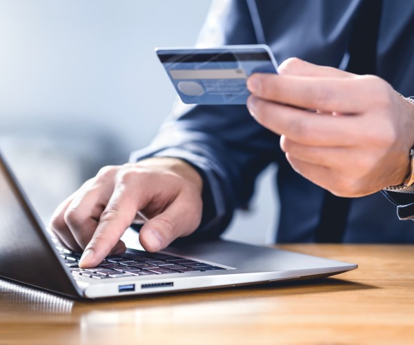 Man using a credit card and laptop to make an online payment