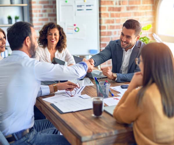 Group of business people shaking hands at a table